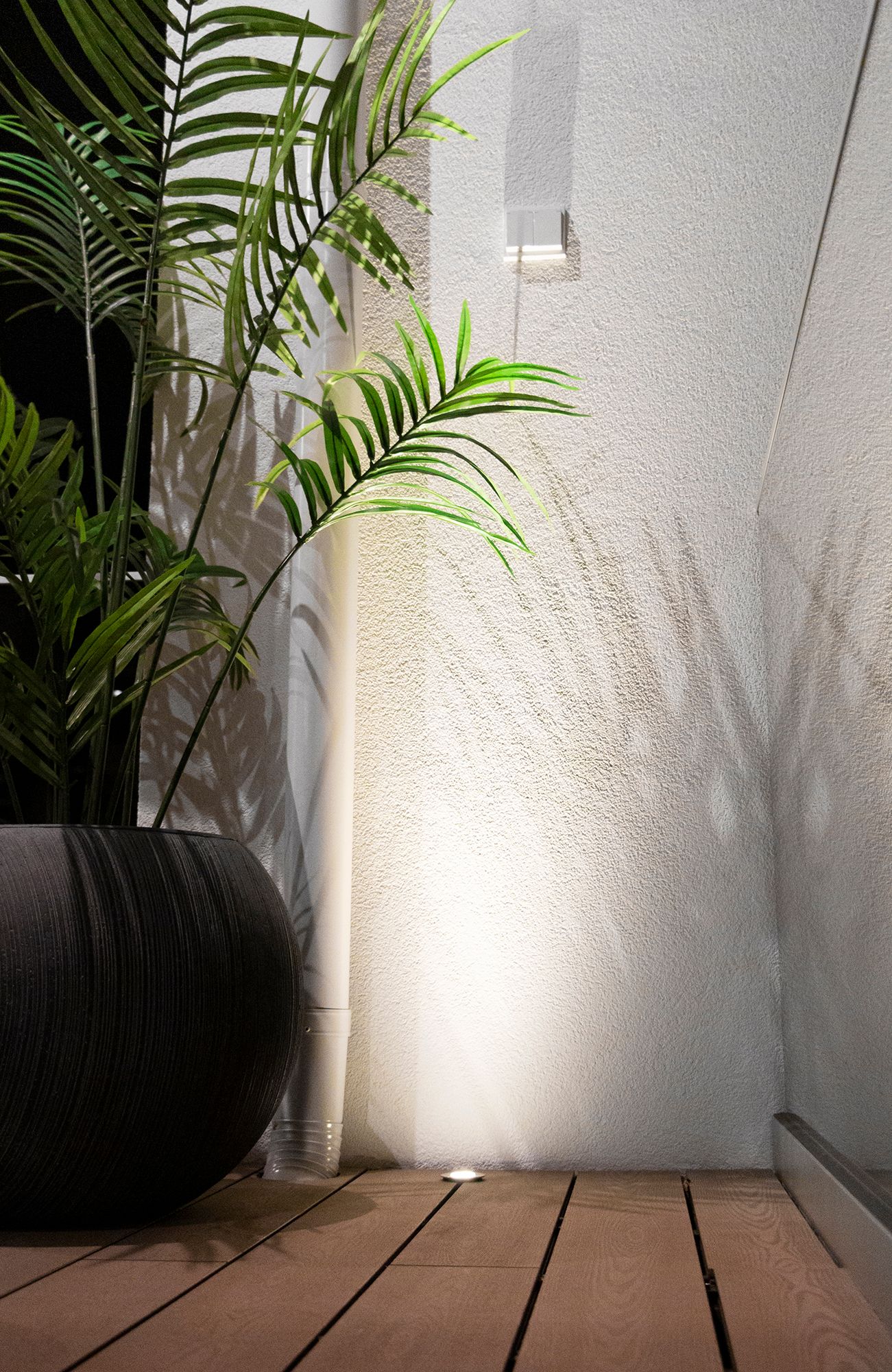 Recessed patio light close enough to the wall to create a reflective surface for the spotlight. Ledstore.fi